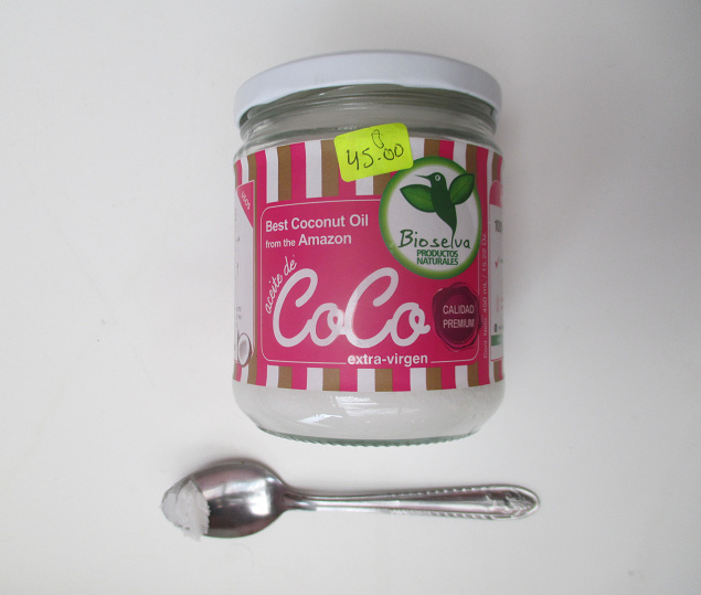 1 Glas Kokos�l mit etwas Kokos�l auf
                einem Teel�ffel
