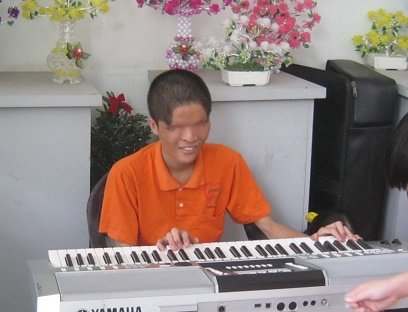 Vietnam Hoh Chi Minh City 2013:
                  Agent-Orange-Opfer ohne Augen spielt am Keyboard