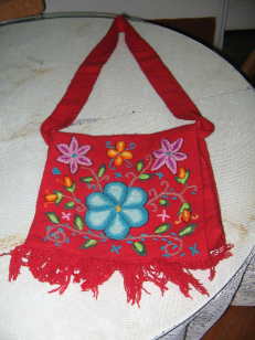 Beispiel einer reinen Handarbeit, eine
                  gestickte, rote Blumentasche aus Ayacucho (Peru)