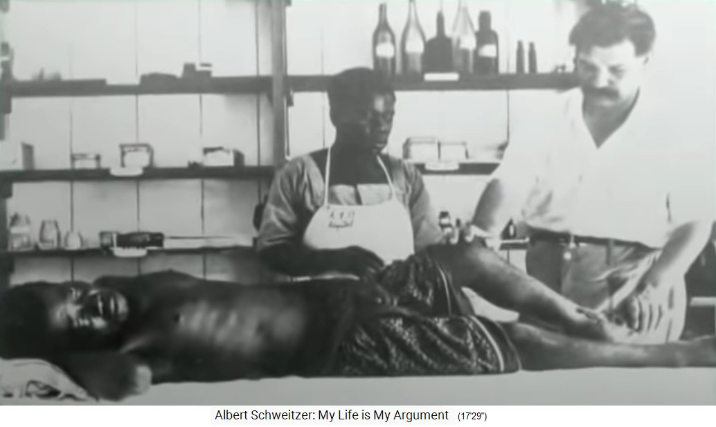 Lambarene, Albert Schweitzer
                      with patient at the operating table [and with the
                      black medical assist Joseph]