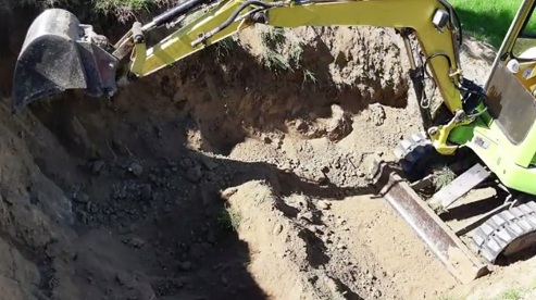 Excavator is working
                              digging a pit into the slope