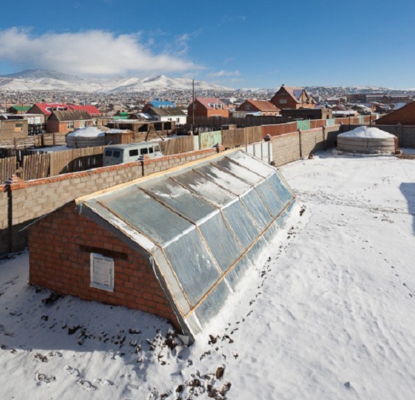 Detta halvt underjordiska grop
                          växthus i Mongoliet producerar mat under tre
                          årstider per år. Ingången är motsatt, som
                          fotspåren avslöjar.