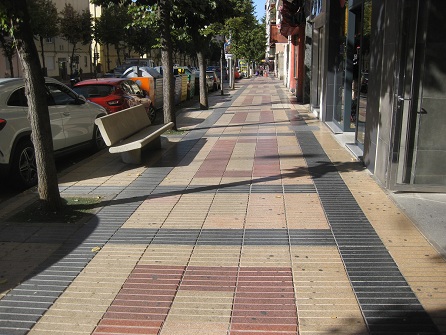 Trottoir / B�rgersteig in gerillten Platten
                      gelb-rot mit schwarzen B�ndern und Sitzbank