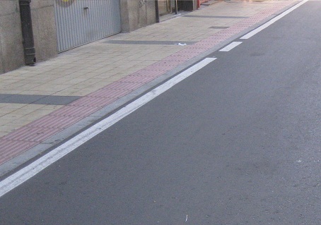 Trottoir in
                    gelben Platten mit rotem Band am Rand und schwarzen
                    Querb�ndern