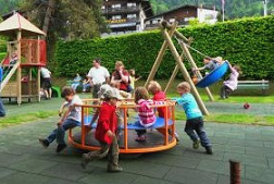Carrusel infantil en un parque infantil del
                      Oberland bernés con niños que juegan