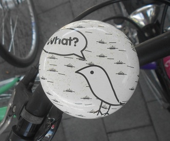 Veloglocke / Fahrradklingel mit einem Comic-Vogel
                und Sprechblase "What?" (Was ist los?)